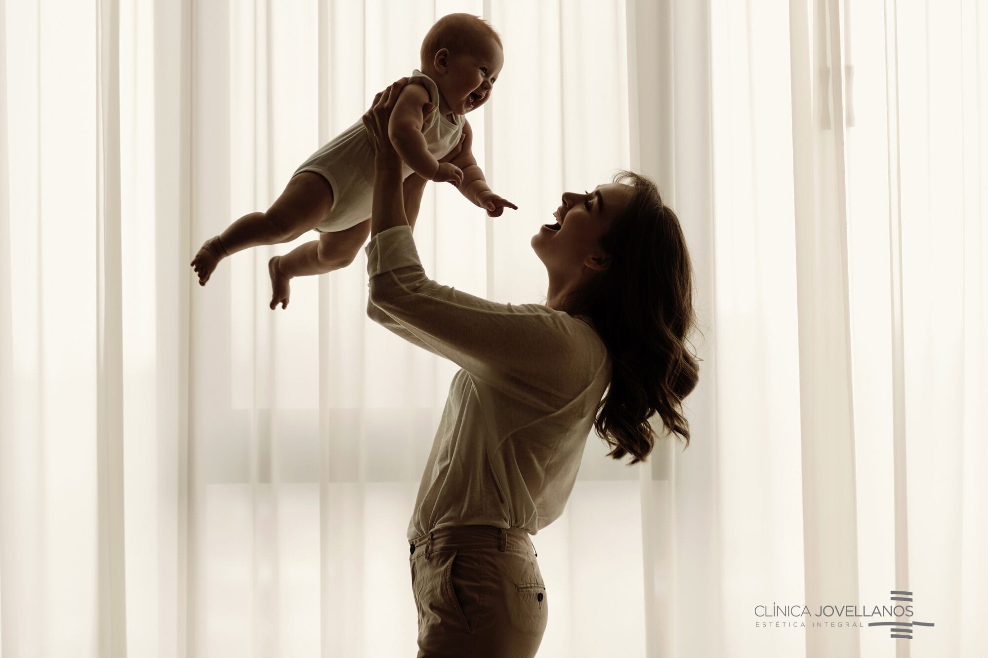 Mujer sosteniendo a su bebé en brazos tras recuperar su figura con un Mommy Makeover en Clínica Jovellanos en Gijón, Asturias.